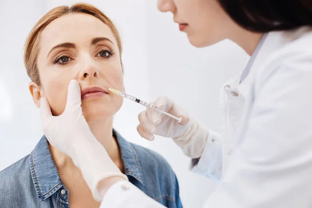 A practitioner assessing the lip area for an aesthetic procedure